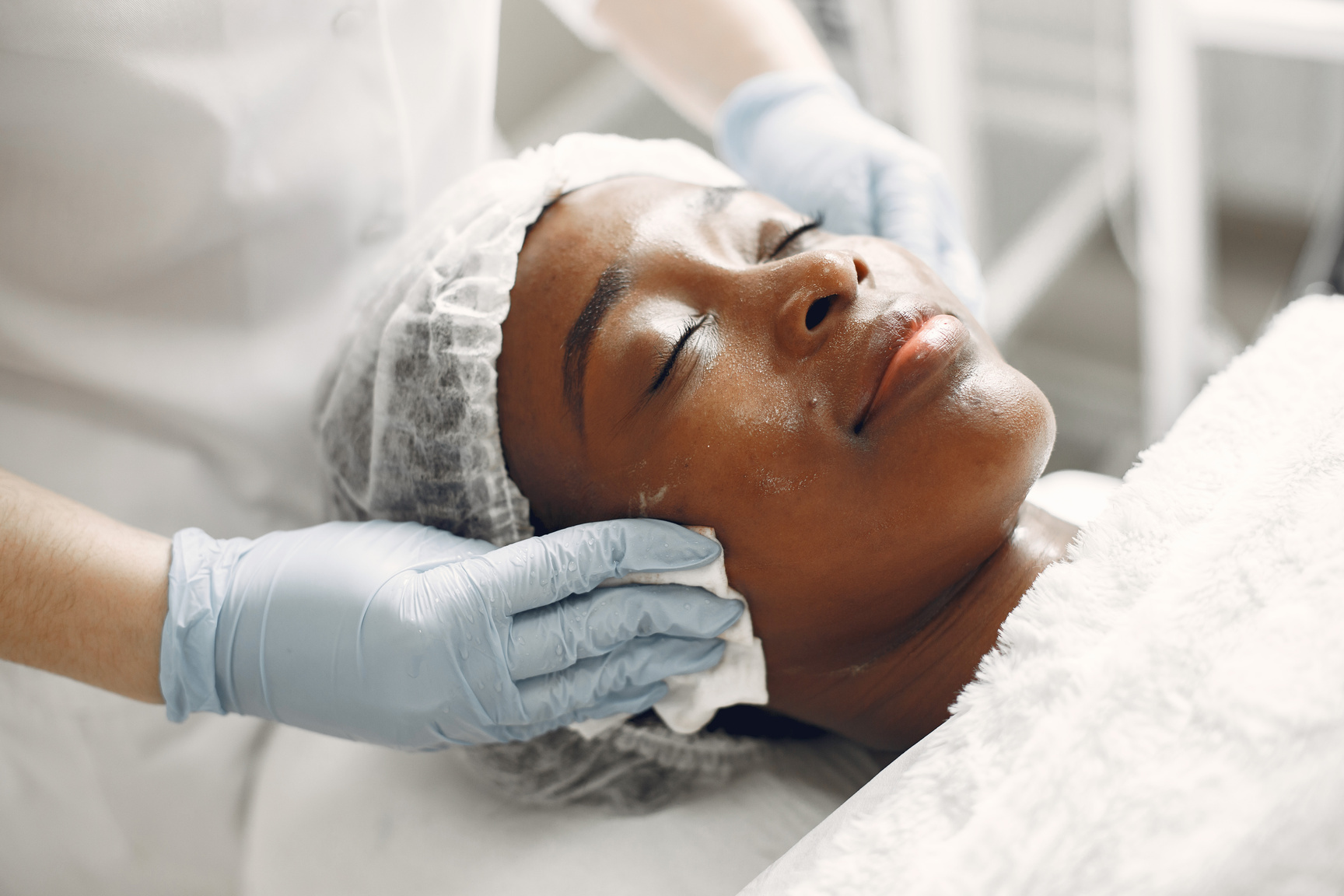 a person getting a facial treatment at an aesthetics clinic.  Variety of Facial treatments available at Bodhi Aesthetics & Nail Spa in Stratford East London