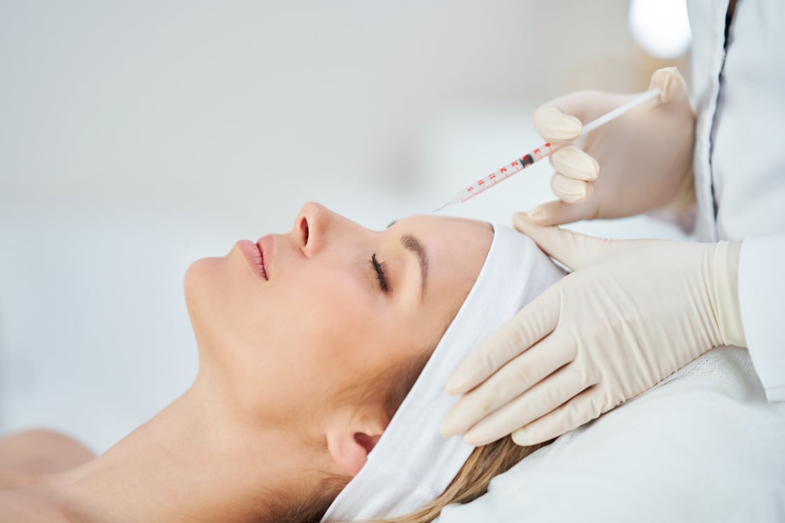 a person getting botox injection in their forehead. Variety of filler and botox treatments available at Bodhi Aesthetics & Nail Spa in Stratford East London. 